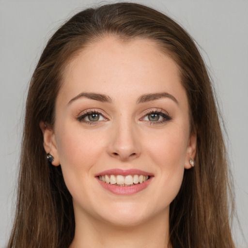 Joyful white young-adult female with long  brown hair and grey eyes