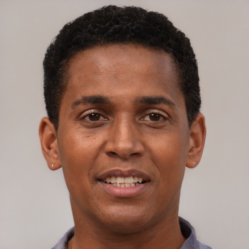 Joyful black young-adult male with short  brown hair and brown eyes