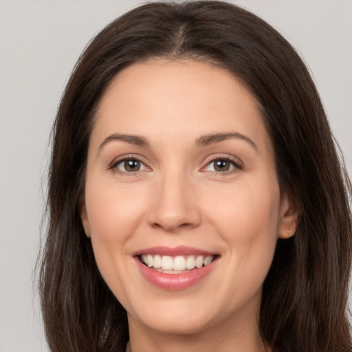 Joyful white young-adult female with long  brown hair and brown eyes