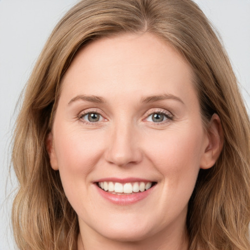 Joyful white young-adult female with long  brown hair and blue eyes