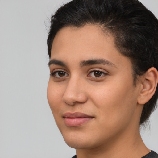 Joyful latino young-adult female with medium  brown hair and brown eyes