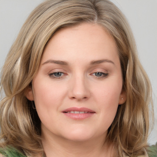 Joyful white young-adult female with medium  brown hair and green eyes