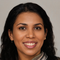 Joyful latino young-adult female with long  brown hair and brown eyes