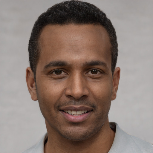 Joyful latino young-adult male with short  brown hair and brown eyes