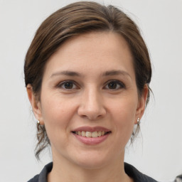 Joyful white young-adult female with medium  brown hair and grey eyes