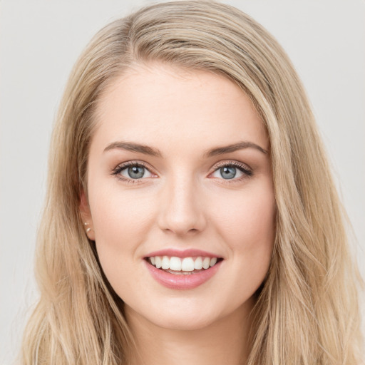 Joyful white young-adult female with long  brown hair and blue eyes