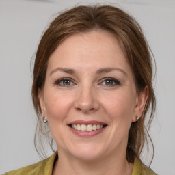 Joyful white adult female with medium  brown hair and grey eyes