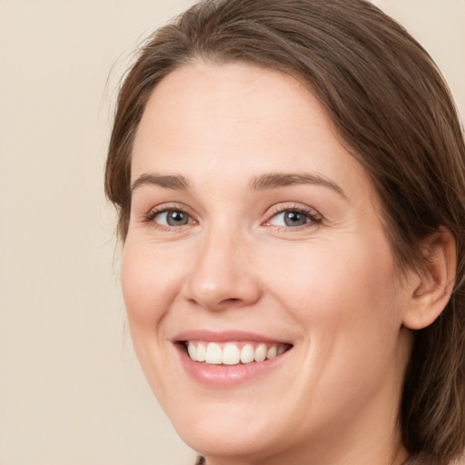 Joyful white young-adult female with medium  brown hair and green eyes