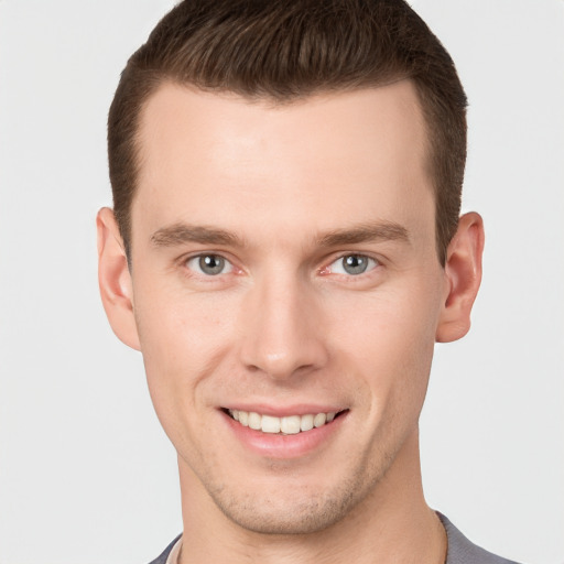 Joyful white young-adult male with short  brown hair and grey eyes