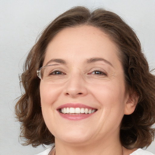 Joyful white adult female with medium  brown hair and brown eyes