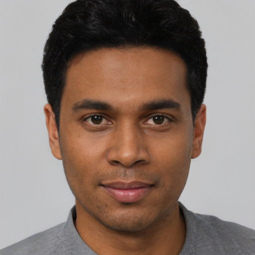 Joyful black young-adult male with short  black hair and brown eyes