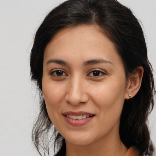 Joyful latino adult female with long  brown hair and brown eyes