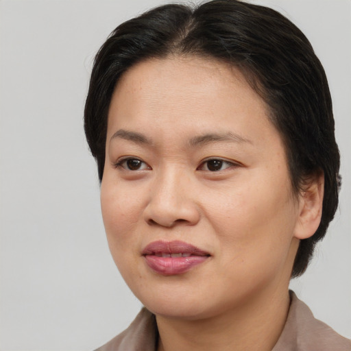 Joyful asian young-adult female with medium  brown hair and brown eyes