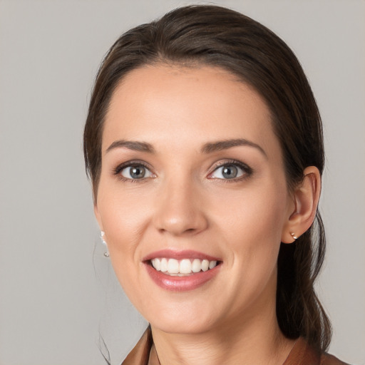 Joyful white young-adult female with medium  brown hair and grey eyes