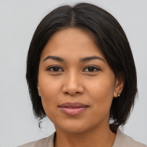 Joyful latino young-adult female with medium  brown hair and brown eyes