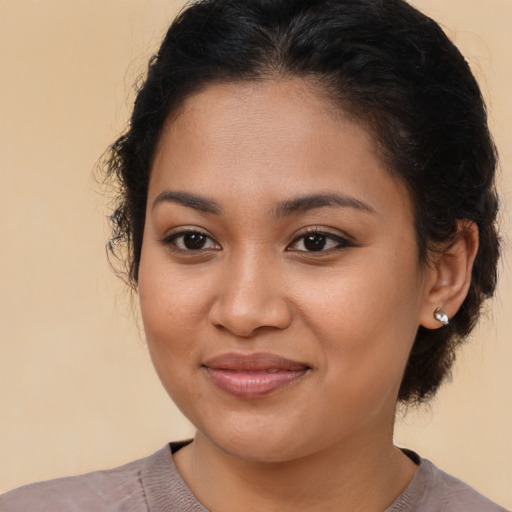 Joyful latino young-adult female with medium  brown hair and brown eyes