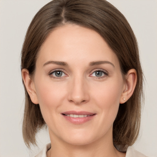 Joyful white young-adult female with medium  brown hair and grey eyes