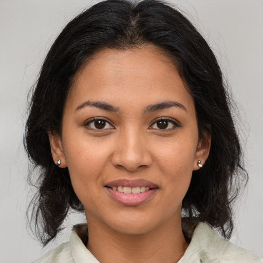 Joyful latino young-adult female with medium  brown hair and brown eyes