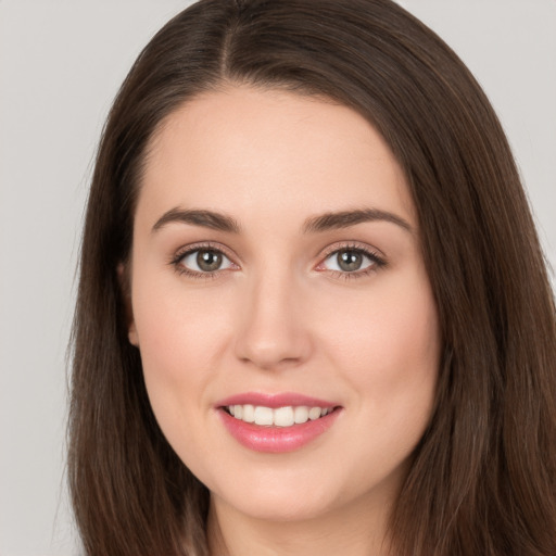 Joyful white young-adult female with long  brown hair and brown eyes