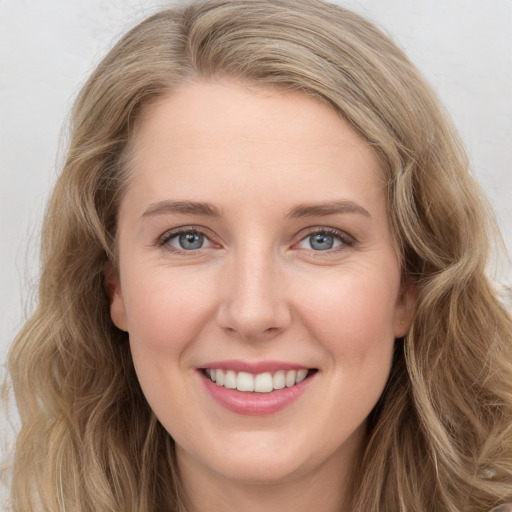 Joyful white young-adult female with long  brown hair and blue eyes