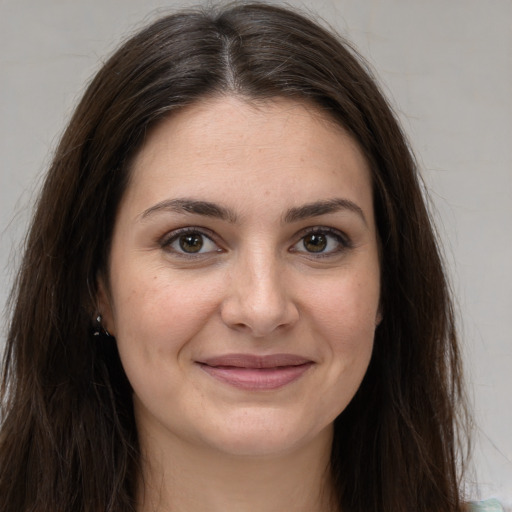 Joyful white young-adult female with long  brown hair and brown eyes