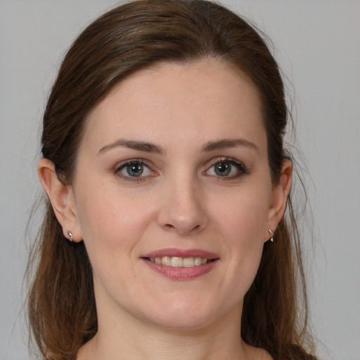 Joyful white young-adult female with long  brown hair and grey eyes