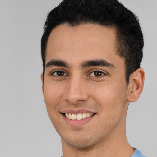 Joyful white young-adult male with short  black hair and brown eyes