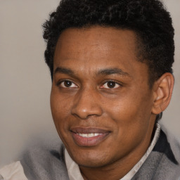 Joyful black adult male with short  black hair and brown eyes