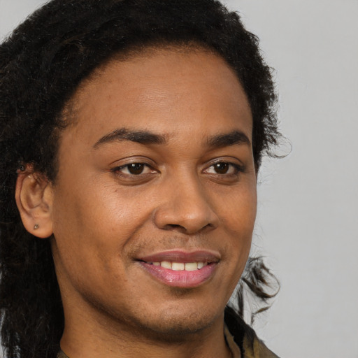 Joyful black young-adult male with long  brown hair and brown eyes
