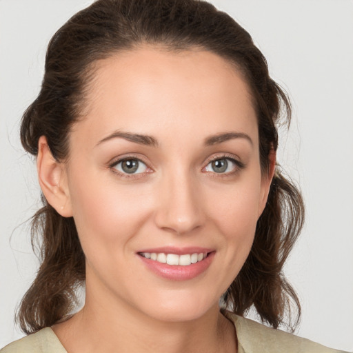 Joyful white young-adult female with medium  brown hair and grey eyes