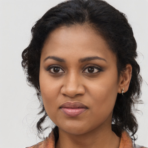Joyful black young-adult female with long  brown hair and brown eyes