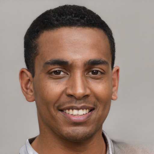 Joyful latino young-adult male with short  black hair and brown eyes