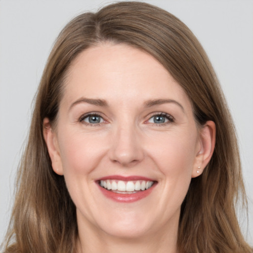 Joyful white young-adult female with long  brown hair and grey eyes