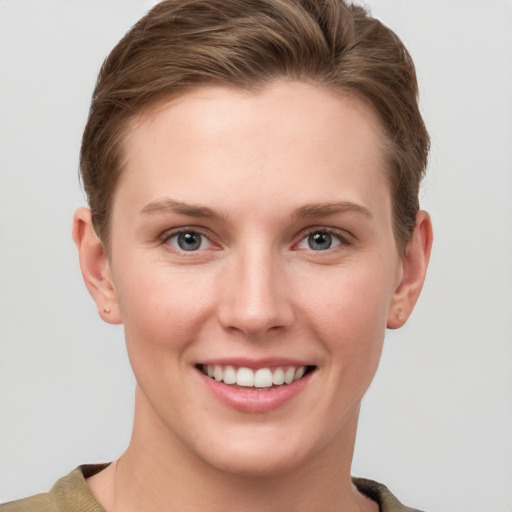 Joyful white young-adult female with short  brown hair and grey eyes