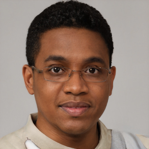 Joyful black young-adult male with short  brown hair and brown eyes