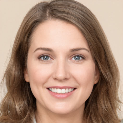 Joyful white young-adult female with long  brown hair and green eyes