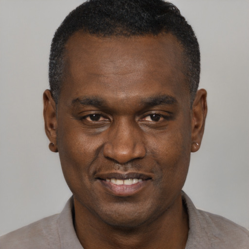 Joyful black adult male with short  brown hair and brown eyes