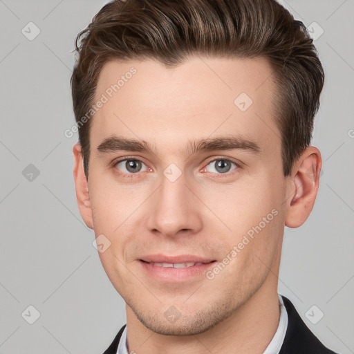 Joyful white young-adult male with short  brown hair and grey eyes