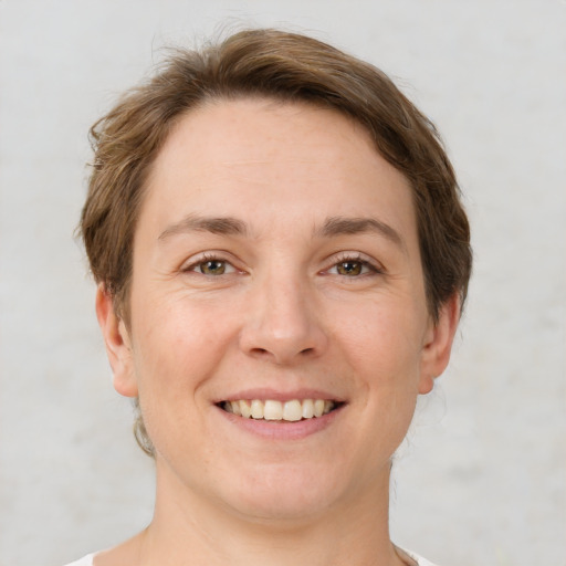 Joyful white young-adult female with short  brown hair and grey eyes