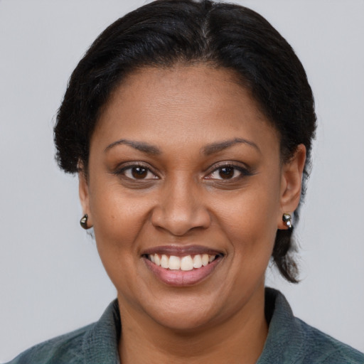 Joyful black adult female with medium  brown hair and brown eyes