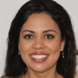 Joyful latino young-adult female with long  brown hair and brown eyes