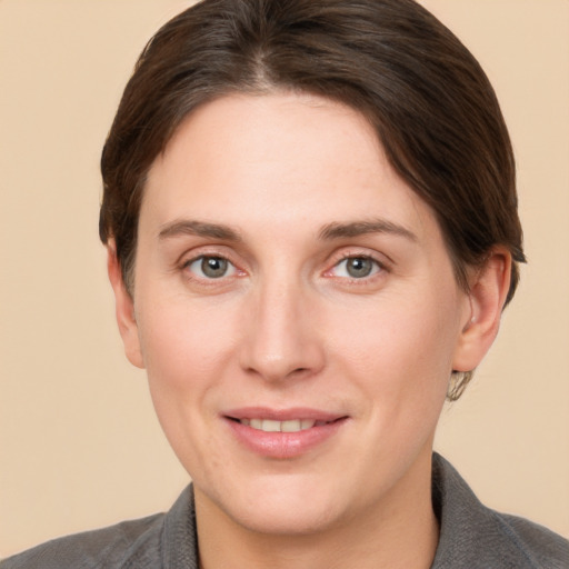 Joyful white young-adult female with short  brown hair and grey eyes