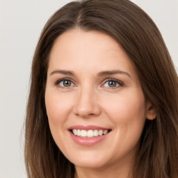 Joyful white young-adult female with long  brown hair and brown eyes