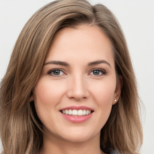 Joyful white young-adult female with long  brown hair and green eyes