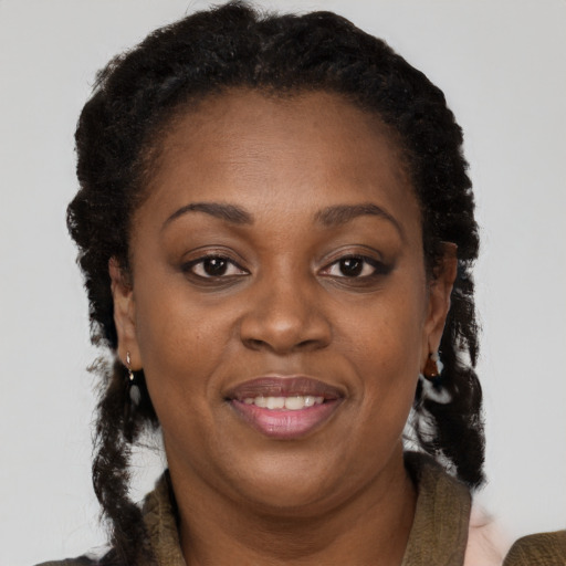 Joyful black adult female with medium  brown hair and brown eyes