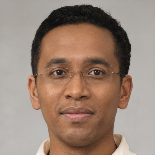 Joyful black young-adult male with short  black hair and brown eyes