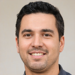 Joyful white young-adult male with short  black hair and brown eyes