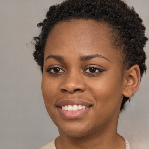 Joyful black young-adult female with short  brown hair and brown eyes