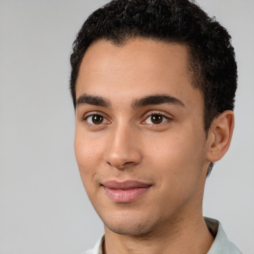 Joyful latino young-adult male with short  black hair and brown eyes