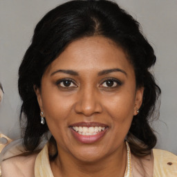 Joyful black adult female with medium  brown hair and brown eyes